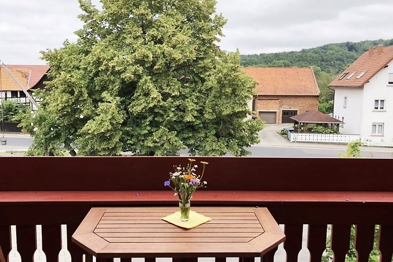 Balkon mit Blumen, Tisch und Stühlen