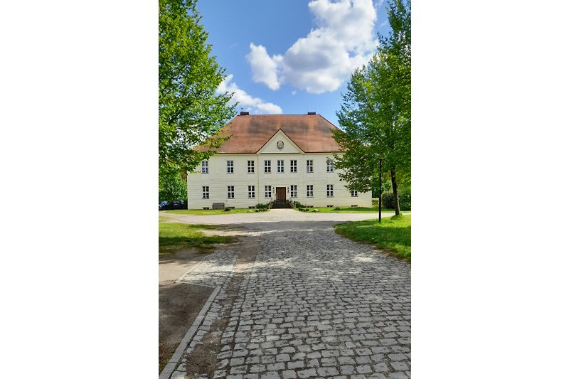 Historisches Anwesen mit Fachwerkhaus und gepflastertem Hof.
