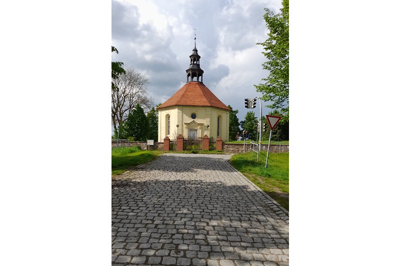 Historische Kapelle mit steinerner Fassade und Kirchturm.
