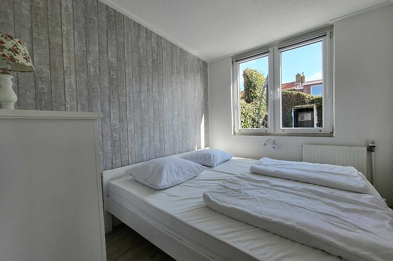 Gemütliches Schlafzimmer mit Sideboard und großem Doppelbett.