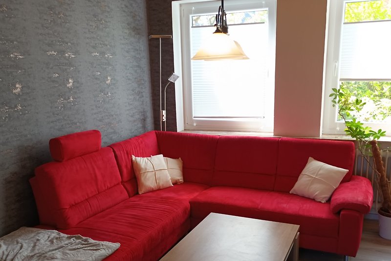 Wohnzimmer mit bequemer Couch, Pflanzen und gemütlicher Beleuchtung.