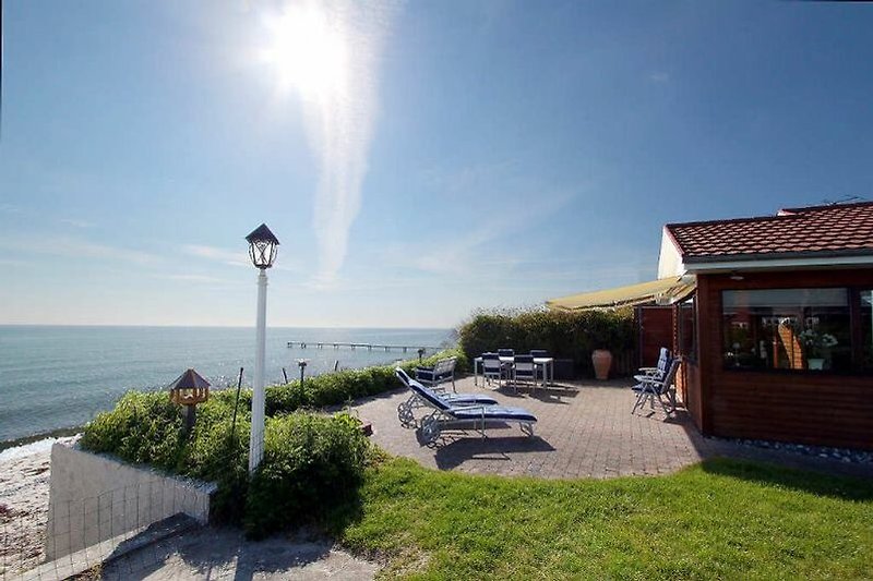 Strandhaus mit Meerblick, Palmen, Strandpromenade.