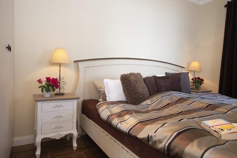 Schlafzimmer mit gemütlichem Bett und masiven Holzmöbeln