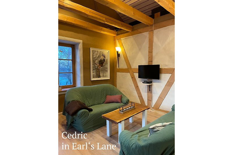 Wohnzimmer mit Holzmöbeln, gemütlicher Beleuchtung und hellem Lehmfachwerk