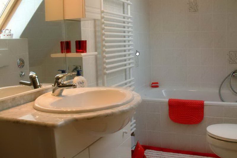 Modernes Badezimmer mit Spiegel, Waschbecken und Badewanne.