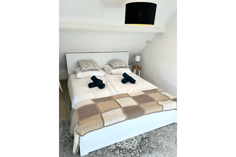 Schlafzimmer mit Holzmöbeln, gemütlichem Bett und stilvollem Dekor.