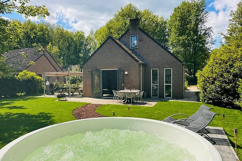 Schönes Ferienhaus mit Garten, Jacuzzi und Außenmöbeln.