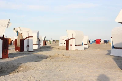 Aan het strand van Carolinensiel liggen kleurrijke strandstoelen op een rij, met uitzicht op de kalme Noordzee. De lucht is helder en de zon schijnt fel, waardoor het perfect weer is voor strandgangers om te ontspannen en te genieten van het rustgevende g Aan het strand van Carolinensiel liggen kleurrijke strandstoelen op een rij, met uitzicht op de kalme Noordzee. De lucht is helder en de zon schijnt fel, waardoor het perfect weer is voor strandgangers om te ontspannen en te genieten van het rustgevende g