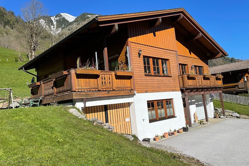 Berglandschaft mit Holzhütte und Bäumen.