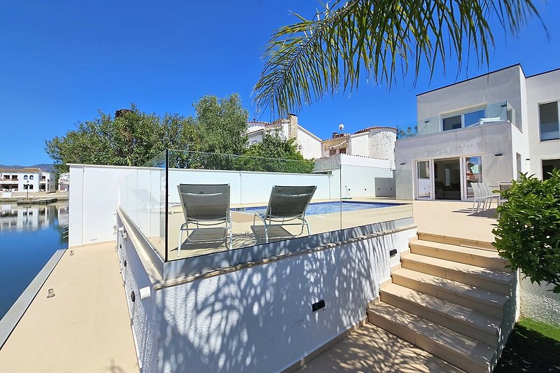 Luxuriöse Villa mit Palmen, Pool und Meerblick.