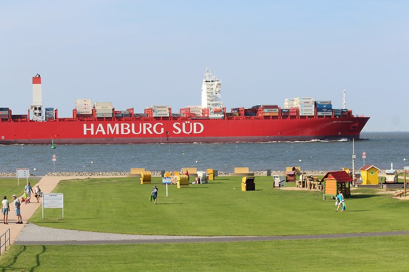 Spektakuläre Aussicht an unserem Strand mit blauem Himmel und grüner Wiese.