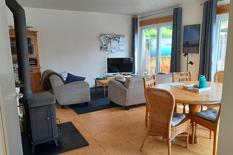 Gemütliches Wohnzimmer mit Holzfußboden, Sofa, TV und Schreibtisch.