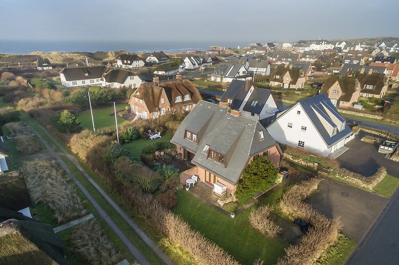 Charmantes Haus mit Garten, Blick auf Stadt und Hügel im Hintergrund.