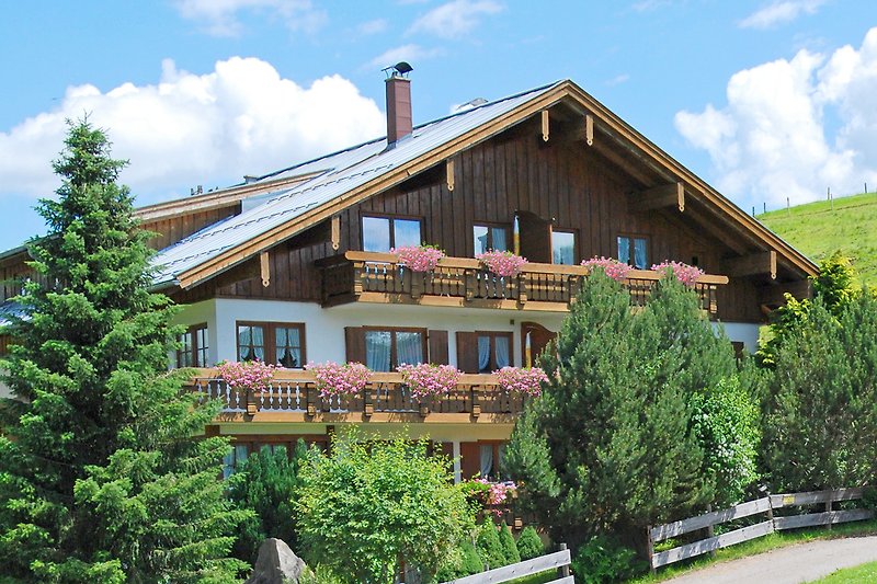 Charmantes Landhaus mit Garten, Holzfassade und Blick auf die Berge.