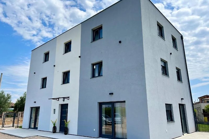 Moderne Wohnung mit Stadtblick, großen Fenstern und grünen Pflanzen.