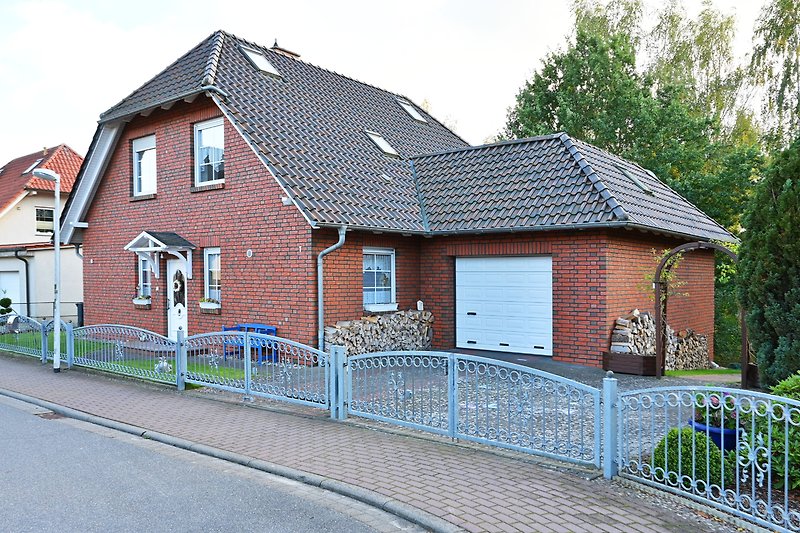 Charmantes Haus mit Ziegelmauerwerk, Holzfassade und Garten.