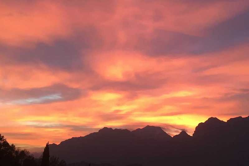 Abenddämmerung über Bergen, Himmel in warmen Farben, ruhige Landschaft.