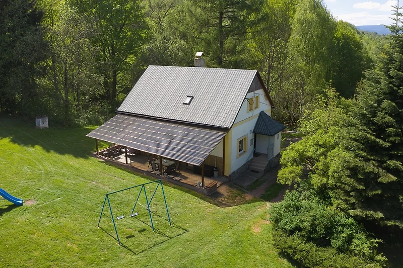 Gemütliche Hütte mit Holzverkleidung, umgeben von Wald und Bergen.