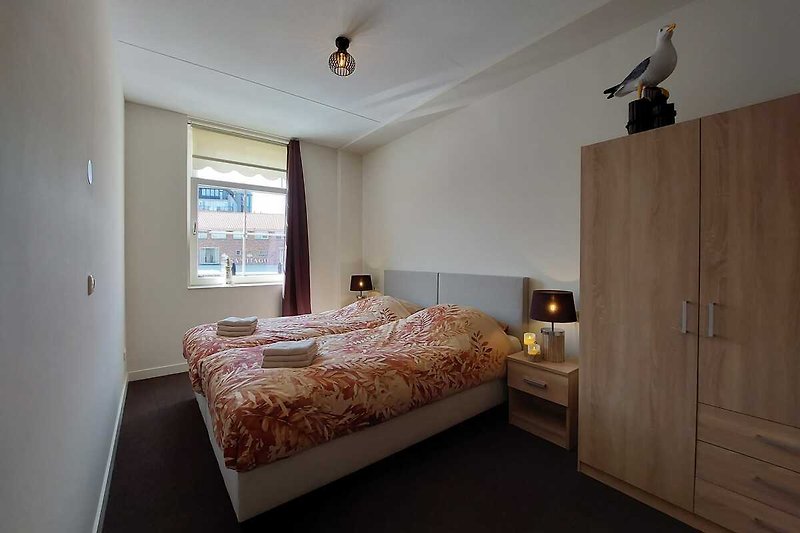 Elegantes Schlafzimmer mit Holzdekor, Bett und großen Fenstern.