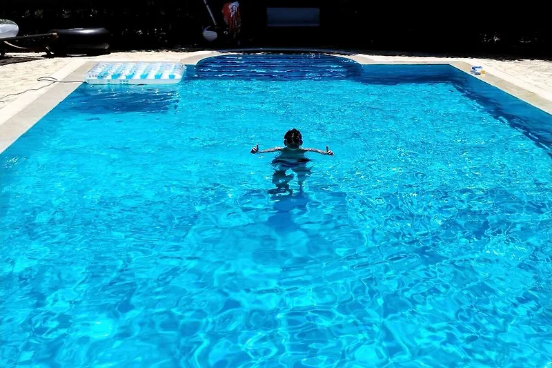 Privater Pool mit Wasserspielen und fröhlichen Kindern.