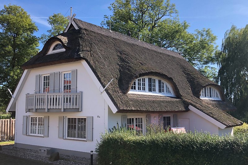 Charmantes Landhaus mit Reetdach, Sprossenfenstern und gepflegtem Garten.