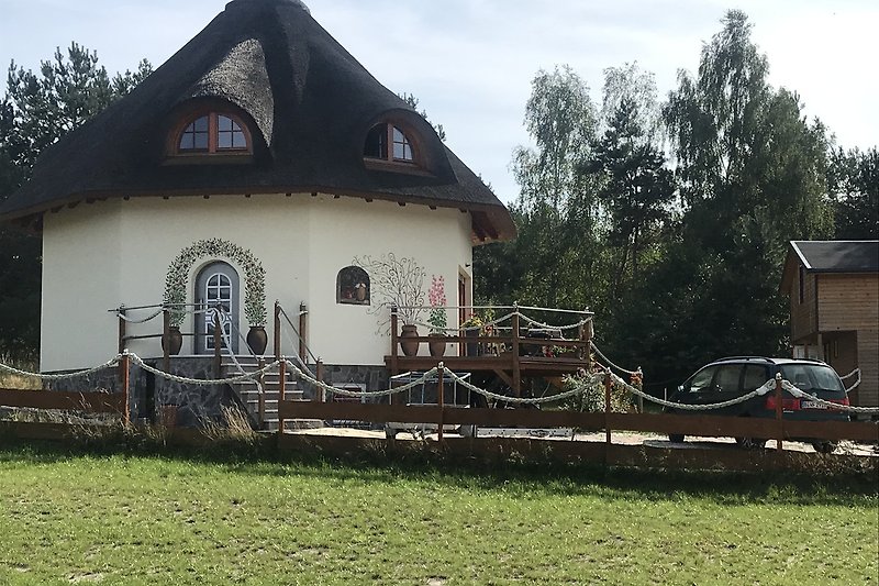 Charmantes Landhaus mit Garten, Veranda und malerischer Landschaft.