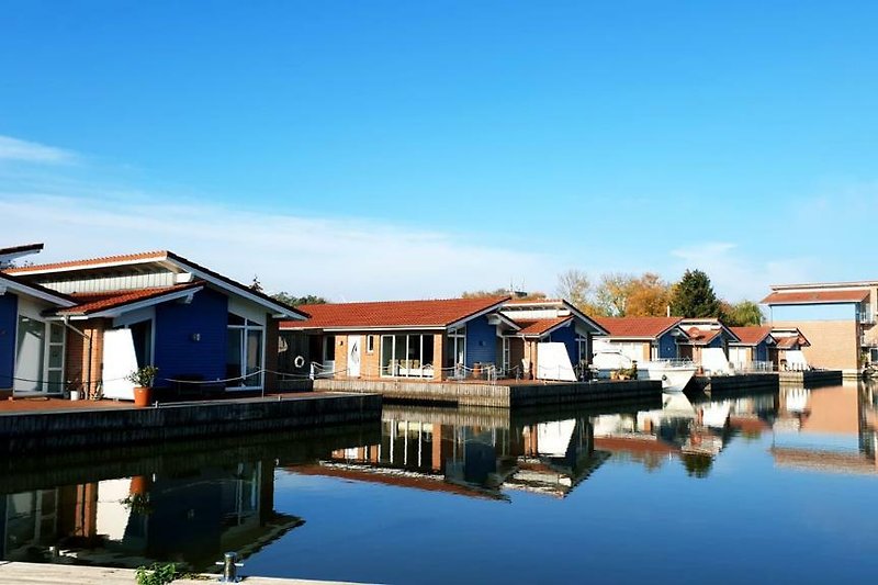 Haus am Wasser mit Booten und Kanalblick.