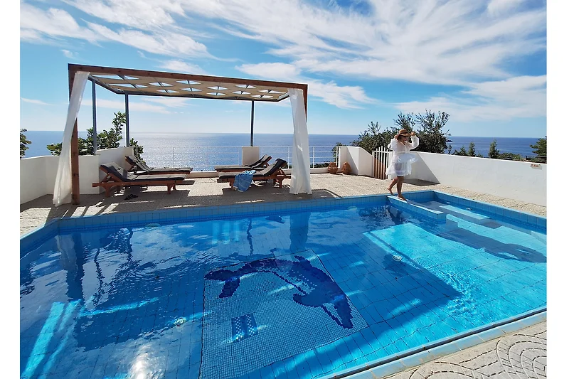 der private Pool mit Sonnenliegen und herrlichem Meerblick