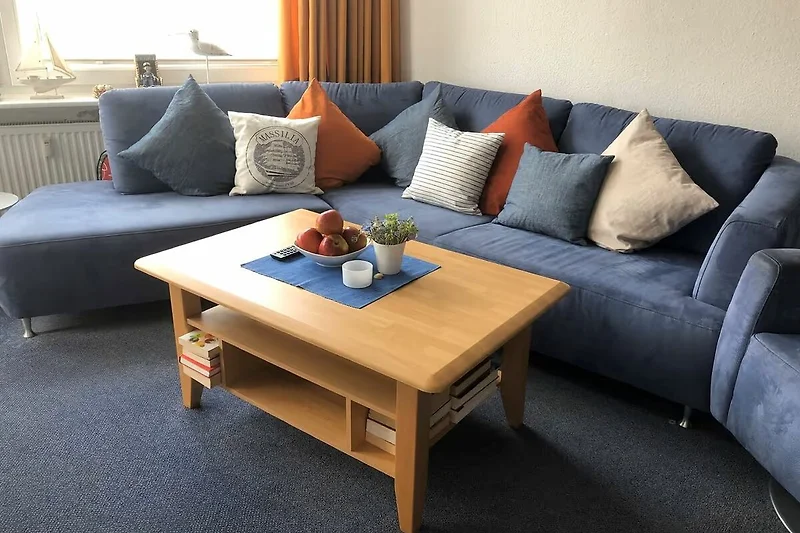 Moderne woonkamer met blauwe bank en houten tafel.