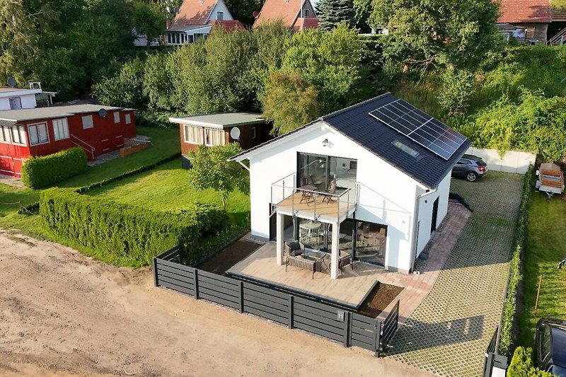 Charmantes Haus mit Garten, Bäumen und schöner Fassade.