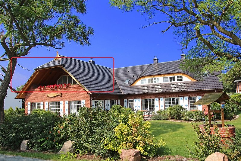 Charmant landhuis met tuin, bomen en een pittoreske gevel.