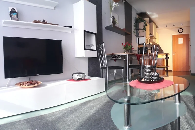 Modernes Wohnzimmer mit Holzregalen, TV und stilvoller Beleuchtung.