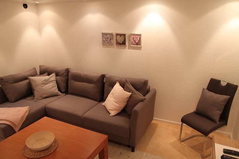 Elegantes Wohnzimmer mit bequemen Sofa, Holztisch und stilvoller Deko.