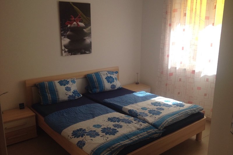 Gemütliches Schlafzimmer mit Holzmöbeln und gemusterten Kissen.