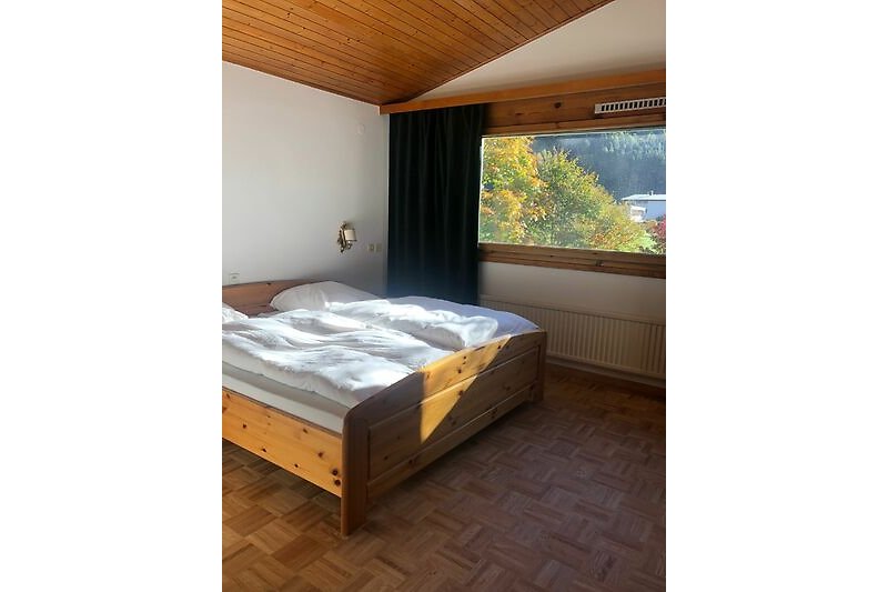 Gemütliches Schlafzimmer mit Holzmöbeln und schöner Aussicht.