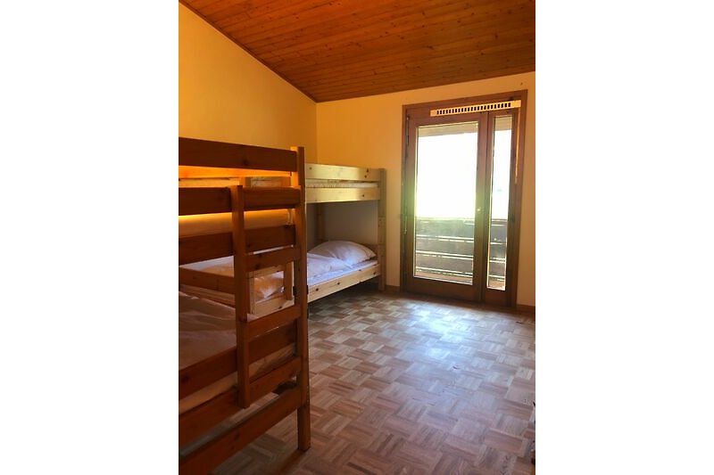 Schlafzimmer mit Etagenbett und Holzboden.