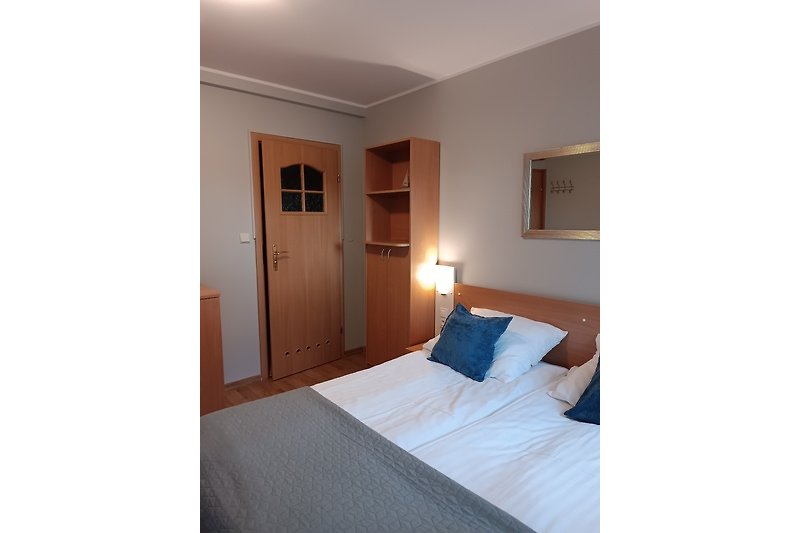 Holzgestaltetes Schlafzimmer mit bequemem Bett und stilvoller Beleuchtung.
