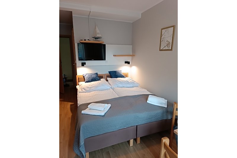 Komfortables Schlafzimmer mit Holzmöbeln und gemütlicher Beleuchtung.
