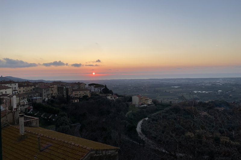 Atemberaubender Sonnenuntergang über der Stadt mit Bergpanorama.