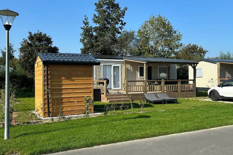 Charmantes Haus mit Garten, Bäumen und Einfahrt in ruhiger Umgebung.