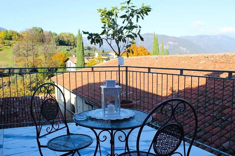 Charmante Terrasse mit Gartenmöbeln und Blick auf den Sonnenuntergang.