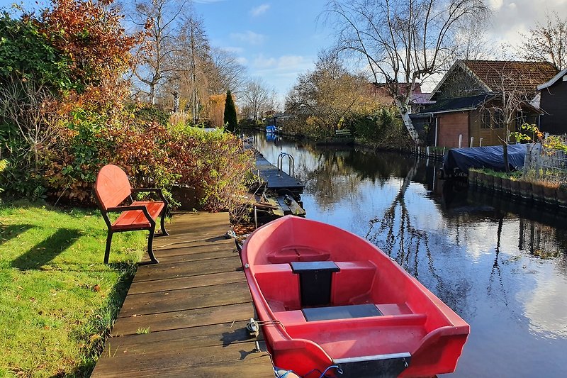 Boote auf ruhigem Kanal mit Bäumen und Wolken im Hintergrund.