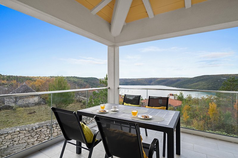 Balkon mit Holzdekor, Tisch und Stühlen für entspannte Stunden.