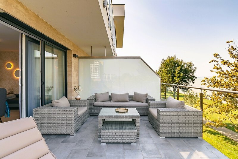 Balkon mit Outdoor-Möbeln und Blick auf den Pool.