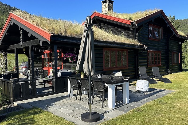 Rustikale Veranda mit Holzmöbeln und Gartenblick.