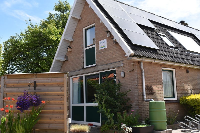 Gemütliches Haus mit Solarpanelen und gepflegtem Garten.