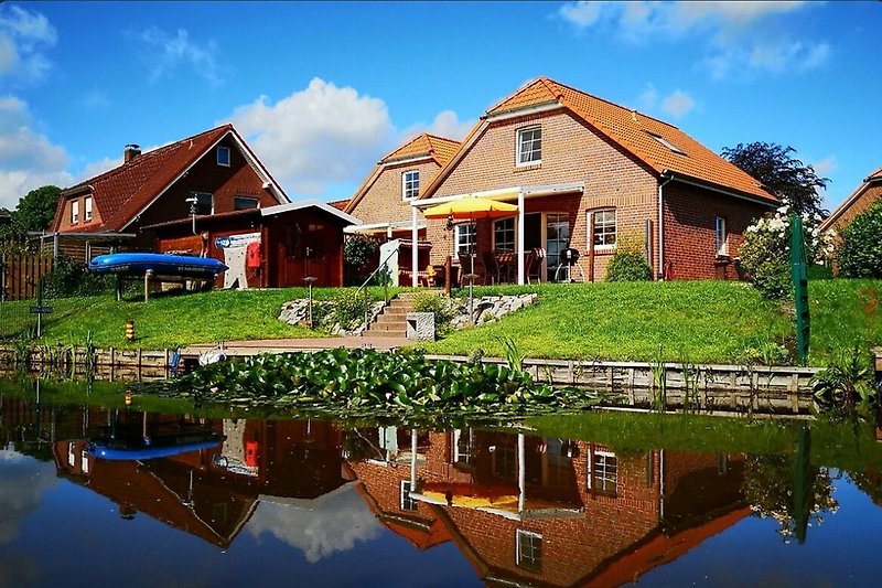 Huus am Siel in Eilsum - Blick vom Wasser auf Haus und Garten