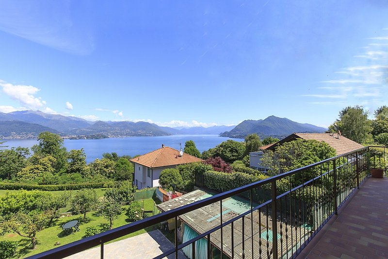 Balkonblick auf Berge und See mit malerischem Alpenpanorama.