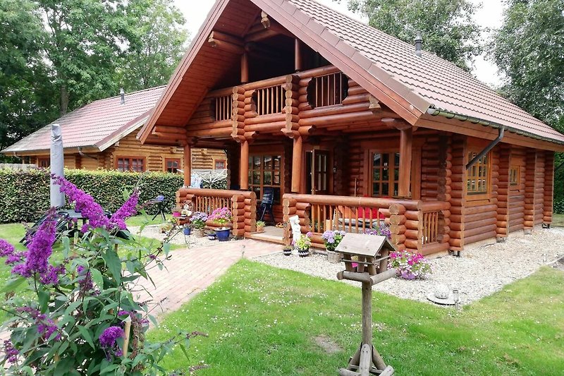 Gemütliche Hütte mit Veranda und Garten im rustikalen Stil.