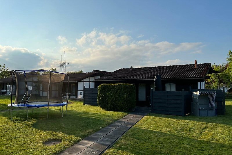 Cottage mit Garten, Rasen und Gartenhäusern im Hinterhof.